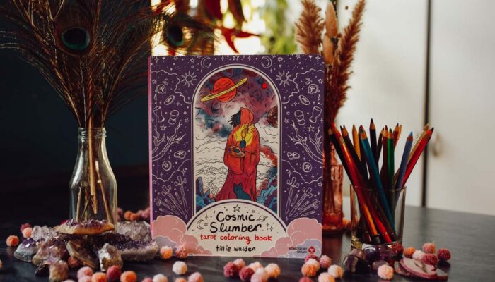 Cosmic Slumber Tarot Coloring Book auf dekoriertem Tisch mit Buntstiften